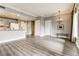 Open-concept living room with light gray walls, hardwood flooring, chandelier, and a partial kitchen view at 30 Strada Di Villaggio # 143, Henderson, NV 89011
