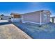 Exterior angle shot of a single-story home highlighting the side entrance and gravel driveway at 3581 W Dyer Rd, Pahrump, NV 89048