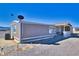 Exterior angle view of a single-story home with a covered porch and spacious gravel surroundings at 3581 W Dyer Rd, Pahrump, NV 89048
