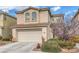 Traditional two-story home with a two-car garage, desert landscaping, and a tile roof under a cloudy sky at 3964 Irvin Ave, Las Vegas, NV 89141