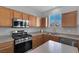 Galley kitchen featuring stainless appliances, gas range, plenty of natural light, and lots of counter space at 3964 Irvin Ave, Las Vegas, NV 89141