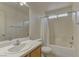 Bright bathroom features a shower-tub combo, neutral tile, and a large countertop with a single sink at 4068 Pistachio Nut Ave, Las Vegas, NV 89115