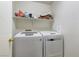 This laundry room includes a washer and dryer with shelving for convenient storage at 4068 Pistachio Nut Ave, Las Vegas, NV 89115