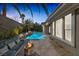 Backyard oasis with a sparkling pool, fire pit, outdoor kitchen, and lush tropical landscaping at 420 Pinnacle Heights Ln, Las Vegas, NV 89144