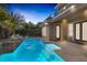 Backyard pool with waterfall feature, lush landscaping, covered patio and mature palm trees at 420 Pinnacle Heights Ln, Las Vegas, NV 89144