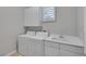Well-lit laundry room features white washer, dryer, sink, white cabinets, and a window for ventilation at 420 Pinnacle Heights Ln, Las Vegas, NV 89144
