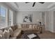Spacious living room with a large sectional sofa, ottoman, and large windows at 420 Pinnacle Heights Ln, Las Vegas, NV 89144