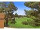 Picturesque view of a lush green golf course, framed by mature pine trees and a clear blue sky at 4961 Tierra Del Sol Dr, Las Vegas, NV 89113