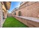A charming backyard features low-maintenance turf and a retaining wall with shrubs for added privacy at 600 N Carriage Hill Dr # 1143, Las Vegas, NV 89138