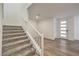 Inviting entryway features modern front door, white banister, carpeted stairs, and wood-look floors at 600 N Carriage Hill Dr # 1143, Las Vegas, NV 89138