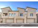 Modern townhome exterior with a two-car garage and light stone accents under a clear blue sky at 600 N Carriage Hill Dr # 1143, Las Vegas, NV 89138