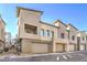 Corner unit townhome exterior showcasing garage, balcony, stone accents, and manicured landscaping at 600 N Carriage Hill Dr # 1143, Las Vegas, NV 89138