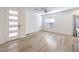 Bright living room featuring modern light fixture, light wood floors, a large window, and a front door at 600 N Carriage Hill Dr # 1143, Las Vegas, NV 89138