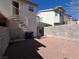 A private backyard featuring red gravel, block wall fencing, and a spiral staircase to a balcony at 6104 Hillside Bloom Ct # 201, Las Vegas, NV 89130