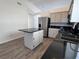 Well-lit kitchen with an island, stainless steel refrigerator and modern countertops at 6104 Hillside Bloom Ct # 201, Las Vegas, NV 89130