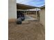 Backyard view featuring a covered patio area, dirt ground, and some trash bags at 6624 Socorro Dr, Las Vegas, NV 89108