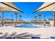 Community pool featuring several seating options and palm trees, located in the center of the neighborhood at 6952 Midnight Bronze St, North Las Vegas, NV 89086