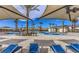 Resort-style community pool with shaded seating and lounge chairs for relaxing in a luxurious outdoor setting at 6952 Midnight Bronze St, North Las Vegas, NV 89086