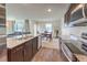 Open concept kitchen with stainless steel appliances flowing to the dining and living areas at 6952 Midnight Bronze St, North Las Vegas, NV 89086