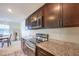 A bright kitchen with granite countertops, stainless steel appliances, and dark wood cabinetry at 6952 Midnight Bronze St, North Las Vegas, NV 89086