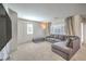 Comfortable living room featuring plush carpeting, a large sofa, and plenty of natural light at 6952 Midnight Bronze St, North Las Vegas, NV 89086