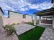 Landscaped backyard featuring a stone patio, artificial grass, providing a low-maintenance and visually appealing outdoor space at 7708 Mojave Wind Ave, Las Vegas, NV 89113