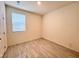 Minimalist bedroom with a bright window, neutral walls, and laminate flooring, offering a blank canvas at 7708 Mojave Wind Ave, Las Vegas, NV 89113