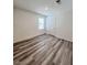 Bright room with wood-look laminate flooring and a window for natural light at 7708 Mojave Wind Ave, Las Vegas, NV 89113