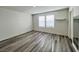 Bright room with wood-look laminate flooring and two large windows at 7708 Mojave Wind Ave, Las Vegas, NV 89113
