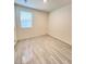 Simple bedroom featuring a large window, neutral walls, and laminate flooring, offering a blank canvas at 7708 Mojave Wind Ave, Las Vegas, NV 89113