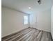 Bedroom featuring wood-look laminate flooring, white walls, and a single window at 7708 Mojave Wind Ave, Las Vegas, NV 89113