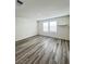 Bright room with wood-look laminate flooring and two large windows at 7708 Mojave Wind Ave, Las Vegas, NV 89113