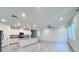 Open-concept living room with modern tile flooring, stainless steel appliances, and a large kitchen island at 7708 Mojave Wind Ave, Las Vegas, NV 89113