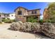 A desert landscaped front yard featuring a two-story home with a two car garage at 774 Wigan Pier Dr, Henderson, NV 89002