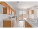 Kitchen with wooden cabinets, white appliances, granite counters and sliding glass doors at 774 Wigan Pier Dr, Henderson, NV 89002