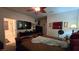 Bright bedroom featuring a large television, ceiling fan, and warm, neutral-toned walls, offering a comfortable retreat at 8824 Martin Downs Pl, Las Vegas, NV 89131