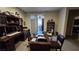 Spacious home office featuring a large desk, extensive built-in shelving, and an exterior view from the sliding door at 8824 Martin Downs Pl, Las Vegas, NV 89131
