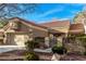 Inviting exterior of a home featuring a garage, gated entry, and desert-style landscaping with mature bushes and rock features at 8920 Litchfield Ave, Las Vegas, NV 89134