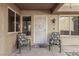 Welcoming front porch featuring decorative chairs, windows, and a secure entry door, framed by desert landscaping at 8920 Litchfield Ave, Las Vegas, NV 89134