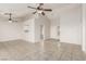 Open living room with neutral tile flooring, ceiling fans, and access to kitchen and entryway at 8920 Litchfield Ave, Las Vegas, NV 89134