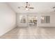 Expansive living room featuring neutral tile flooring, ceiling fans, and a sliding glass door to the outside at 8920 Litchfield Ave, Las Vegas, NV 89134