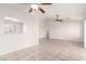 Open living room featuring neutral tile flooring, ceiling fans, and access to the kitchen at 8920 Litchfield Ave, Las Vegas, NV 89134