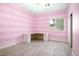 Bright bedroom featuring pink striped walls, light wood floors, modern lighting, and built-in desk at , Las Vegas, NV 89131