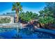 Backyard pool and spa featuring rock waterfall and lush palm trees, perfect for relaxation at , Las Vegas, NV 89131