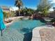 Inviting backyard pool featuring a rock waterfall, mature landscaping, and a spa at , Las Vegas, NV 89131