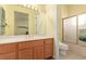 Bathroom with a wood vanity, large mirror, and shower with sliding glass doors at 10709 Brinkwood Ave, Las Vegas, NV 89134