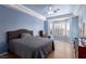 Serene main bedroom featuring tray ceilings, wood-like floors, and plenty of natural light from windows at 10709 Brinkwood Ave, Las Vegas, NV 89134