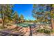 Outdoor shuffleboard court framed by trees, gravel and grass, offering a recreational space for relaxation and community enjoyment at 10709 Brinkwood Ave, Las Vegas, NV 89134