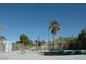 A sunny backyard features a pool surrounded by a white fence and lush greenery at 1108 Sidehill Way, Las Vegas, NV 89110