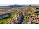 Expansive aerial view of a desert community showcasing lush landscaping and mountain views at 1223 Casa Palermo Cir, Henderson, NV 89011